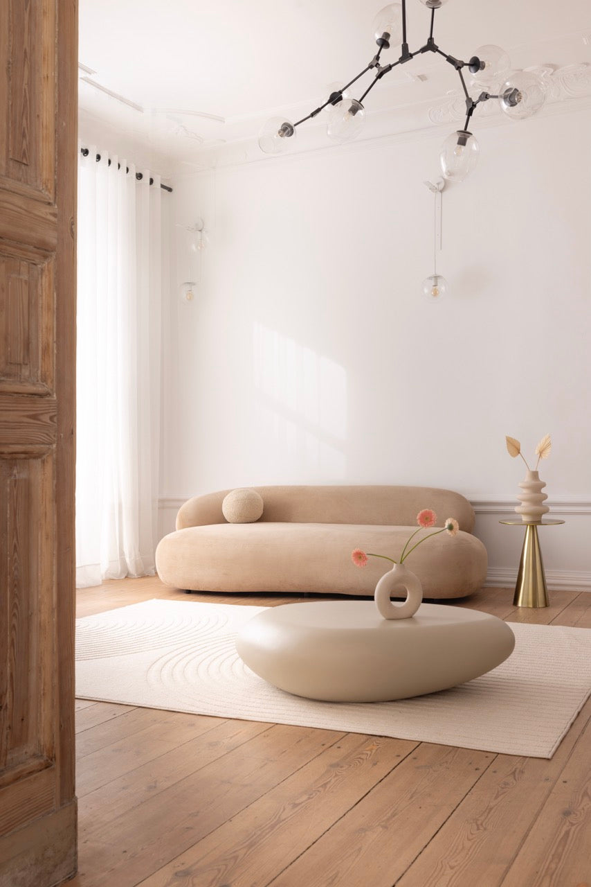 Minimalistyczne studio fotograficzne we Wrocławiu z beżową sofą i jasnym wystrojem.