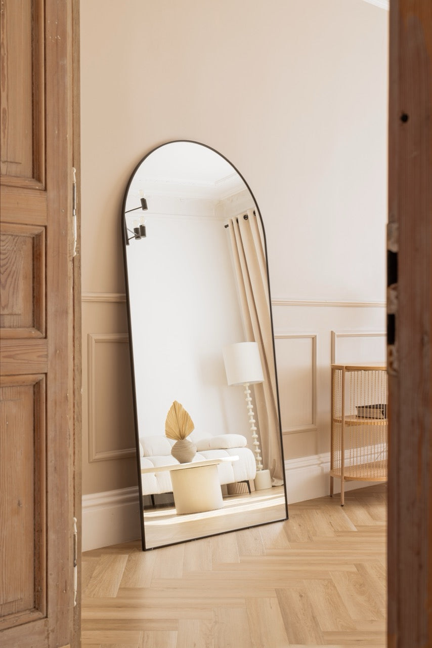 Minimalistyczne wnętrze Silky Studio z dużym stojącym lustrem, jasną sofą i drewnianą podłogą – idealne do sesji fotograficznych.