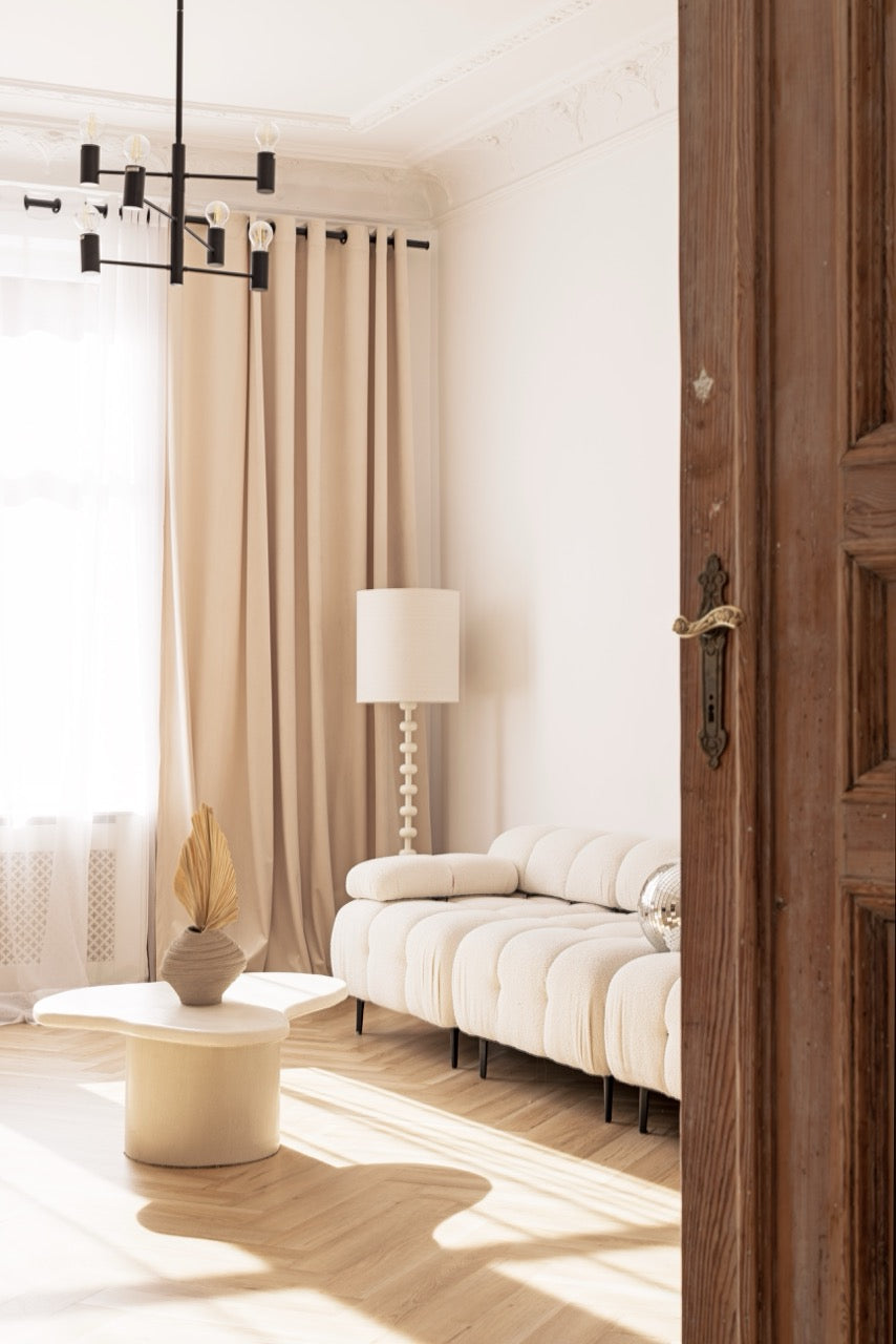Jasne i nowoczesne wnętrze Silky Studio z designerską sofą, stolikiem dekoracyjnym i lampą stojącą – idealne do sesji zdjęciowych.